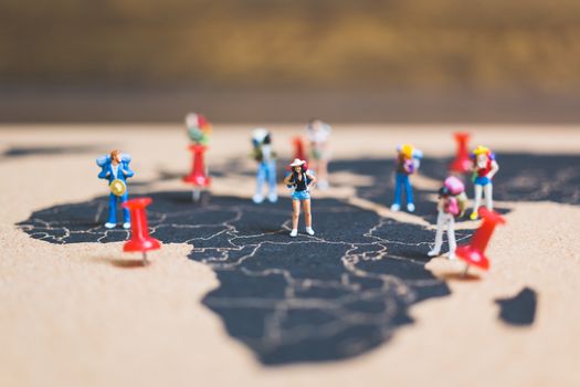Miniature people backpacker walking on world map, Tourism and travel concept