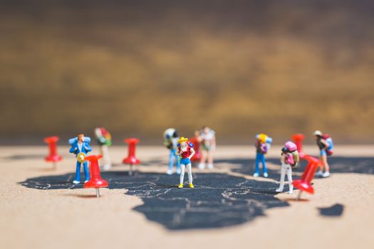 Miniature people backpacker walking on world map, Tourism and travel concept
