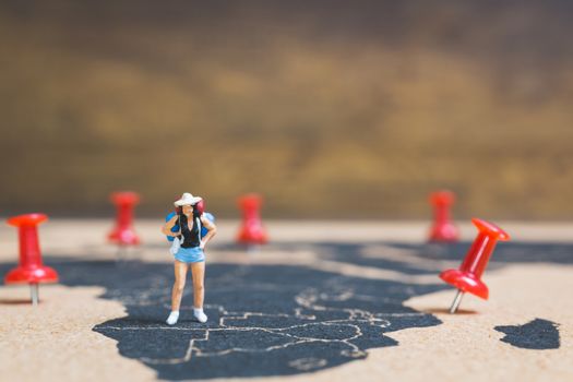 Miniature people backpacker walking on world map, Tourism and travel concept