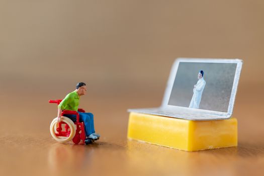 Miniature people , Male patient talk consult with doctor using video call on laptop , online doctor concept