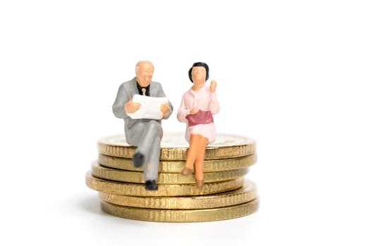 Miniature people: Businessman sitting on stack of coin , Money and financial concepts.