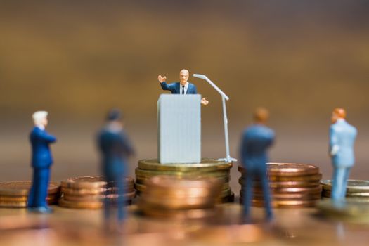 Miniature people : Businessman speaking on the podium , Business and finance investment concept