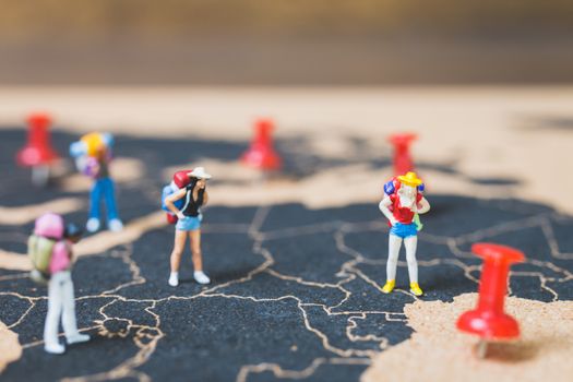 Miniature people backpacker walking on world map, Tourism and travel concept