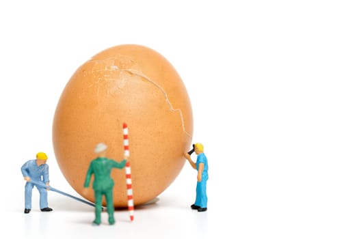 Miniature people work at Easter-eggs for Easter day on white background