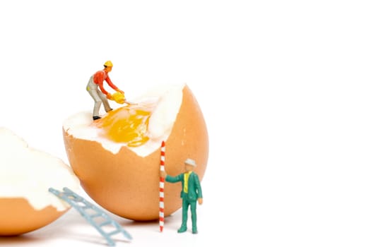 Miniature people work at Easter-eggs for Easter day on white background