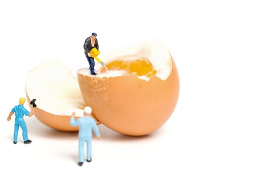 Miniature people work at Easter-eggs for Easter day on white background
