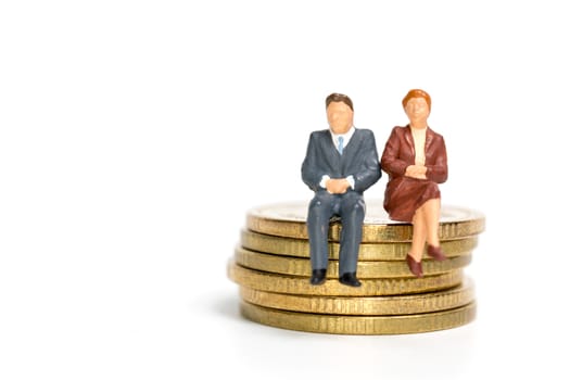 Miniature people: Businessman sitting on stack of coin , Money and financial concepts.