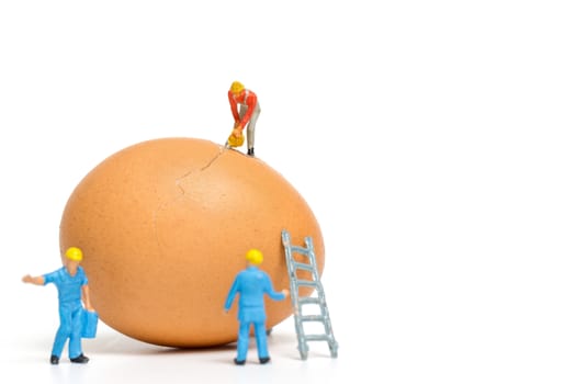 Miniature people work at Easter-eggs for Easter day on white background