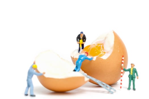 Miniature people work at Easter-eggs for Easter day on white background