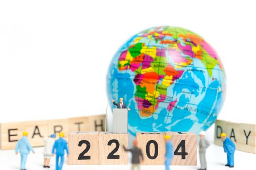 Miniature people : Businessman speaking on the podium , Earth day concept