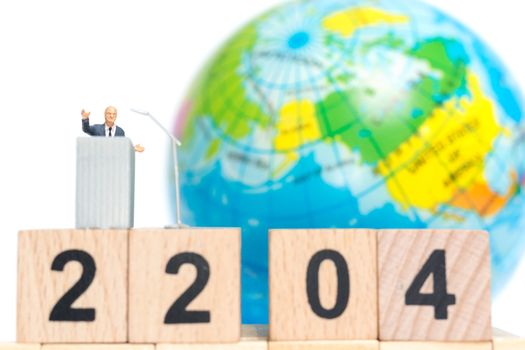 Miniature people : Businessman speaking on the podium , Earth day concept