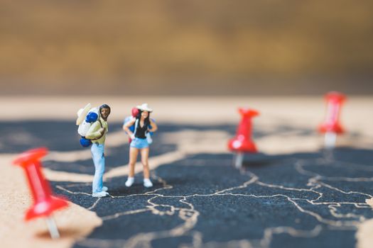 Miniature people backpacker walking on world map, Tourism and travel concept