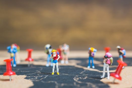 Miniature people backpacker walking on world map, Tourism and travel concept