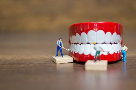 Miniature people : Worker team repairing a tooth ,Healthcare and medical concept