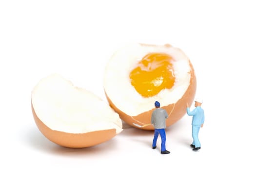 Miniature people work at Easter-eggs for Easter day on white background