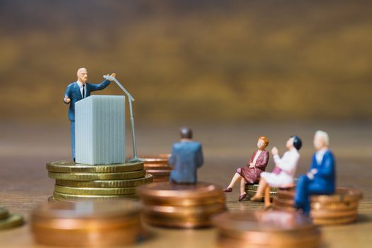 Miniature people : Businessman speaking on the podium , Business and finance investment concept