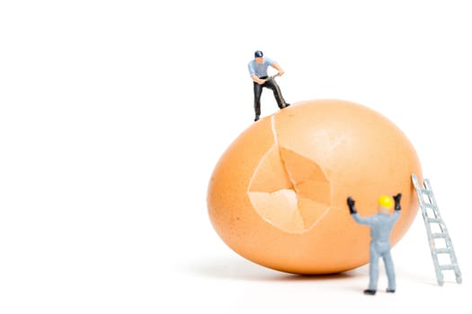 Miniature people work at Easter-eggs for Easter day on white background