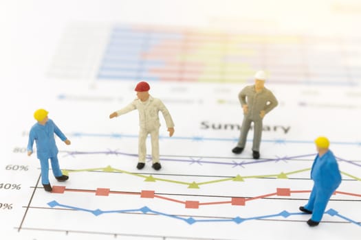 Miniature figures businessman standing on a graph chart  