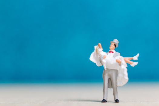 Miniature people : Bride and groom , Couple  on blue background.