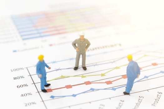 Miniature figures businessman standing on a graph chart  