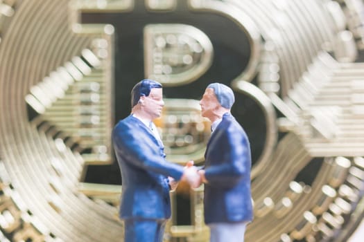 Miniature people: Businessman stand with Bitcoin currency in the form of digital (Cryptocurrency)  , Business concept.