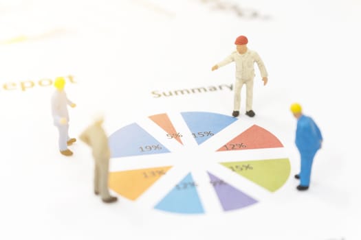 Miniature figures businessman standing on a graph chart  