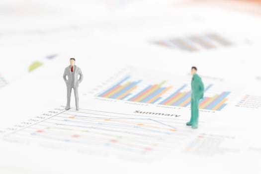 Miniature figures businessman standing on a graph chart