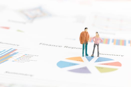 Miniature figures businessman standing on a graph chart