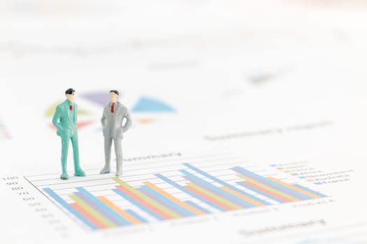 Miniature figures businessman standing on a graph chart