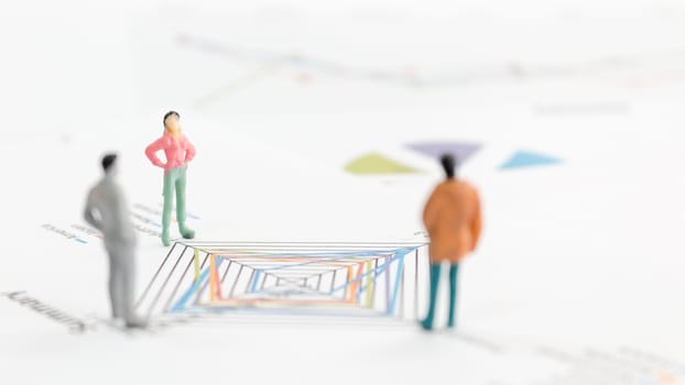 Miniature figures businessman standing on a graph chart
