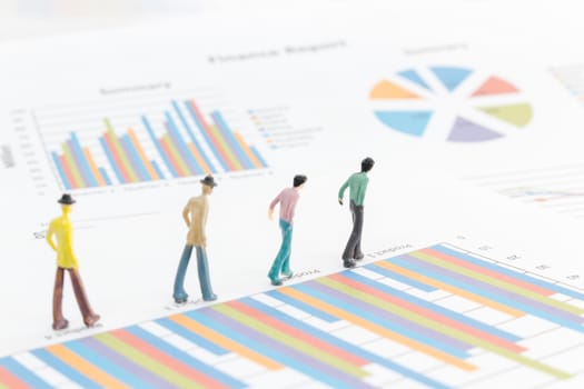Miniature figures businessman standing on a graph chart