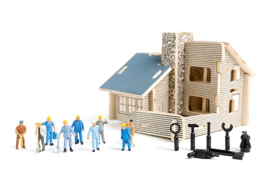 Miniature people : Worker team with tools supplies for repair house on white background , construction concept