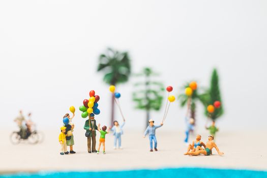 Miniature people : happy family enjoy summer vacation on the beach