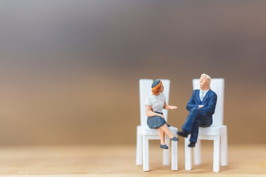 Miniature people Thinking about next great idea on wooden background and copy space for text