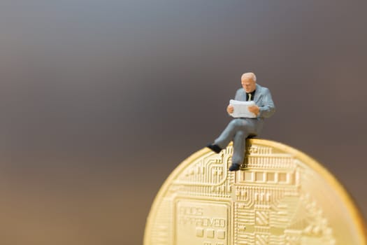 Miniature people: Businessman sitting on Bitcoin currency (Cryptocurrency)  , Business concept.