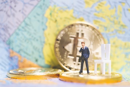 Miniature people: Businessman on stack of coin with world map background , Money and financial business success concept.