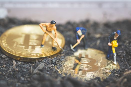 Miniature people : Worker team digging ground to uncover big shiny bitcoin ,  Successful work concept