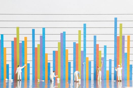 Miniature people : Worker painting business graph on white background , Business growth concept