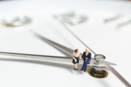 Miniature people Businessman sitting on clock , Concept of Time and Work