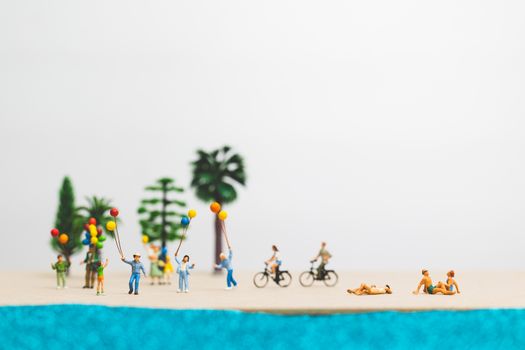 Miniature people : happy family enjoy summer vacation on the beach