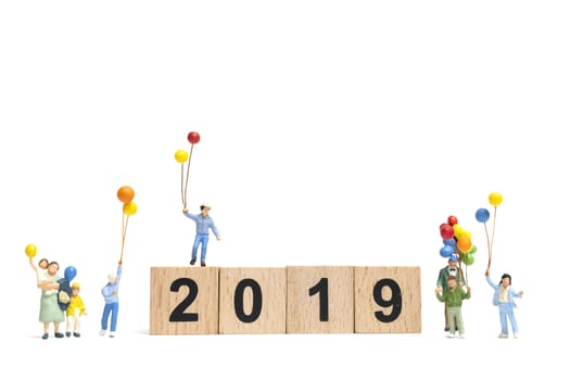 Miniature people : Happy family holding balloon on Number 2019 and copy space for text