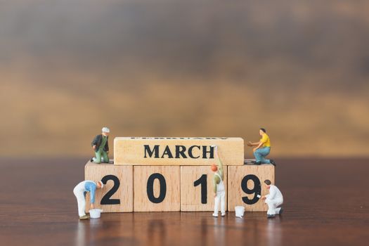 Miniature worker team painting  on wooden block , Happy new year 2019 concept