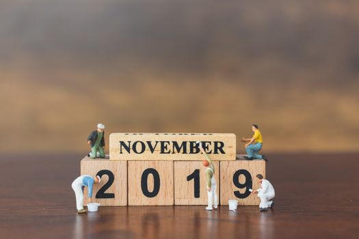 Miniature worker team painting  on wooden block , Happy new year 2019 concept