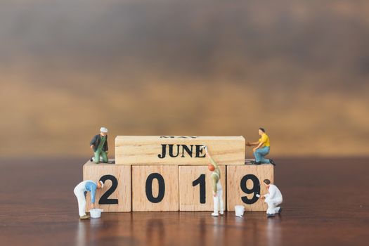 Miniature worker team painting  on wooden block , Happy new year 2019 concept