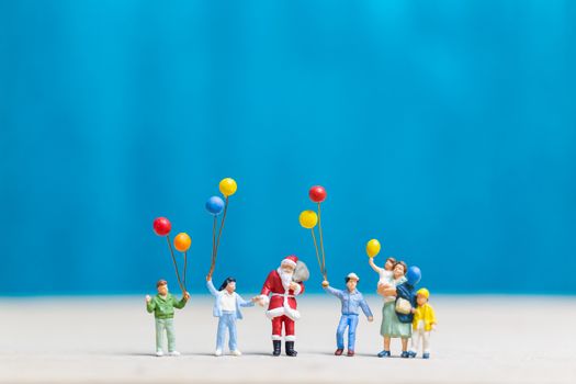 Miniature people: Santa Claus and children holding balloon , Merry Christmas and Happy New Year concept.