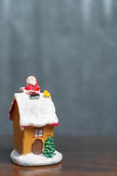 Merry Christmas and happy holidays! Cute Santa Claus sitting on the roof, Christmas legend concept.