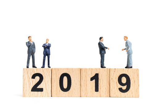 Miniature people : businessman  standing and thinking on wooden block number 2019. on white background