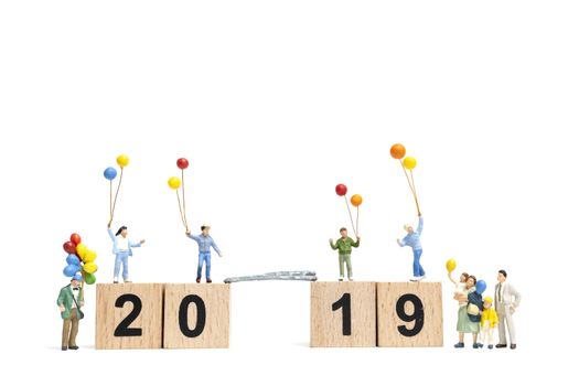 Miniature people : Happy family holding balloon on Number 2019 and copy space for text