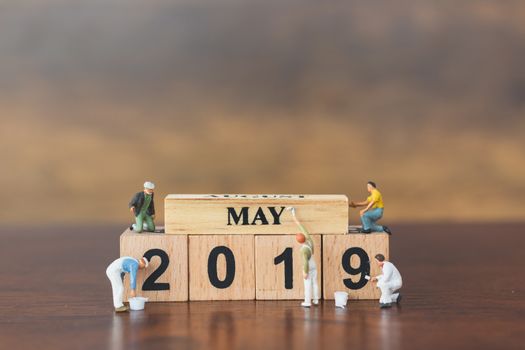 Miniature worker team painting  on wooden block , Happy new year 2019 concept