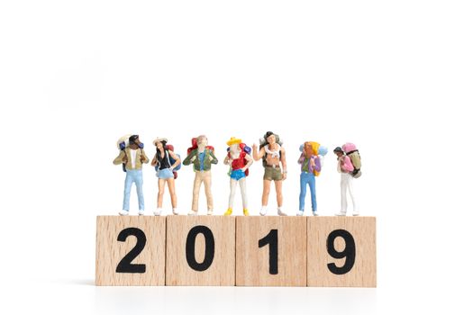 Miniature people Backpacker  on wooden block number 2019. isolated on white background